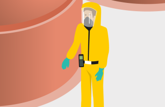 Mitarbeiter in gelbem Schutzanzug steht vor Silos